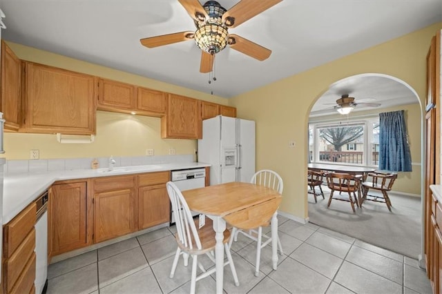 kitchen featuring white appliances, light countertops, a sink, and light tile patterned floors