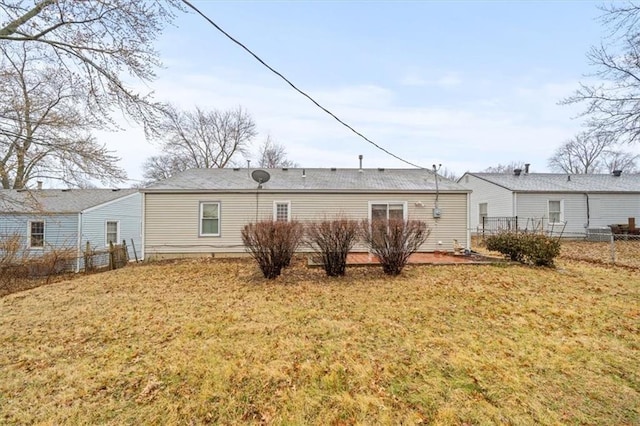 rear view of property featuring fence, a lawn, and a patio