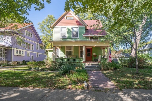 victorian-style house with a porch and a front lawn