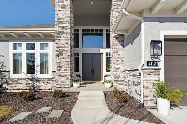 view of exterior entry with stone siding and stucco siding