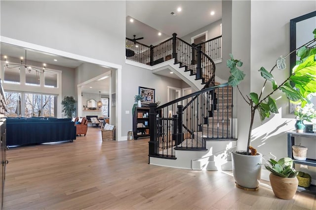 entrance foyer featuring a high ceiling, stairway, recessed lighting, and light wood-style floors