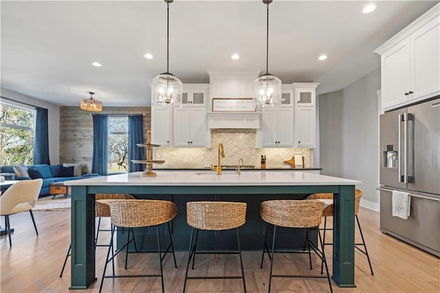 kitchen with high end refrigerator, glass insert cabinets, and white cabinets