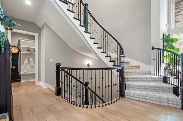 staircase featuring baseboards and wood finished floors