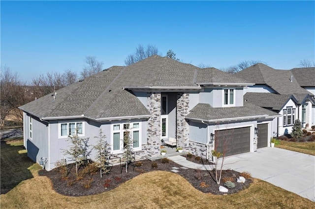 view of front facade with a shingled roof, a front yard, stone siding, and driveway