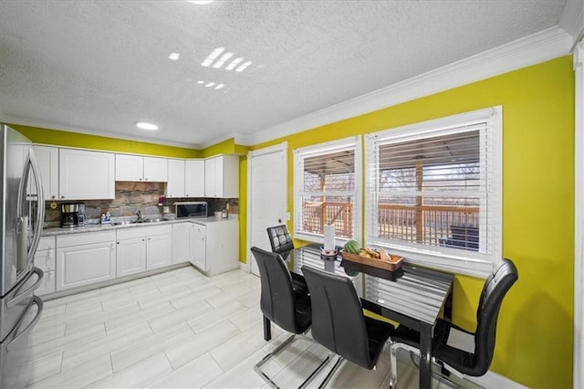 kitchen with sink, crown molding, appliances with stainless steel finishes, backsplash, and white cabinets