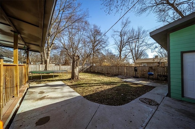 view of yard with a trampoline and a patio