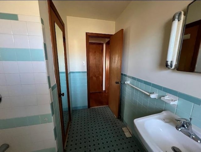 bathroom featuring tile walls and sink