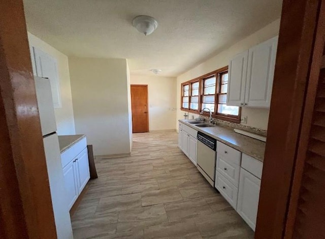 kitchen with white cabinetry, sink, stainless steel dishwasher, and white refrigerator