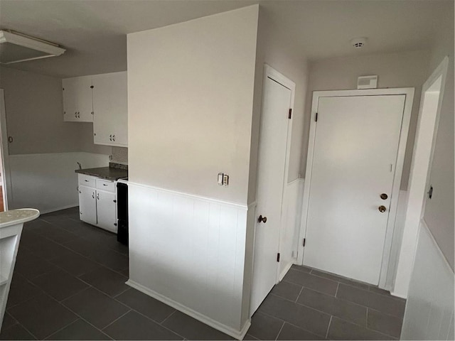 hall featuring dark tile patterned flooring