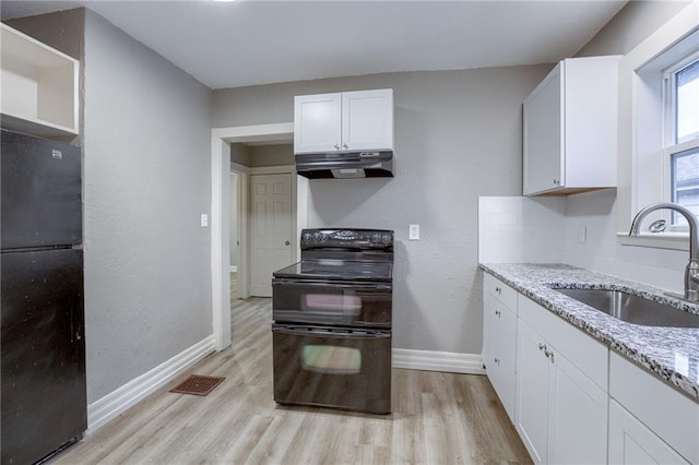 kitchen featuring sink, white cabinets, black appliances, light stone countertops, and light wood-type flooring