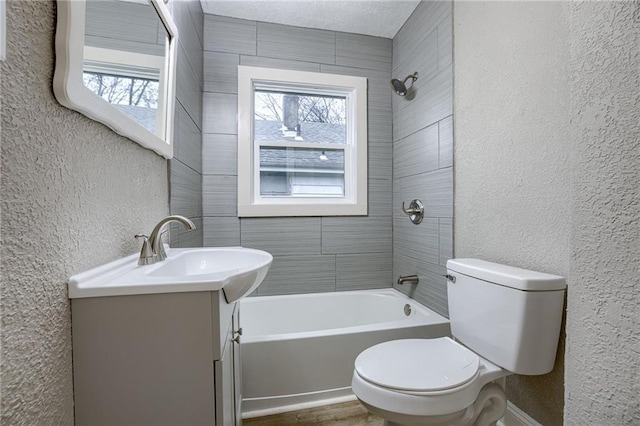 full bathroom with tiled shower / bath combo, vanity, and toilet