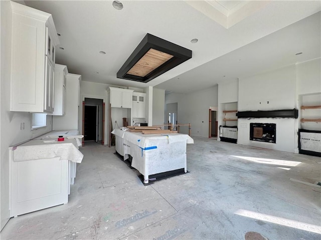 10332 N Potter Ave, Kansas City, MO 64157 - kitchen featuring white cabinets, a center island, light countertops, and concrete floors