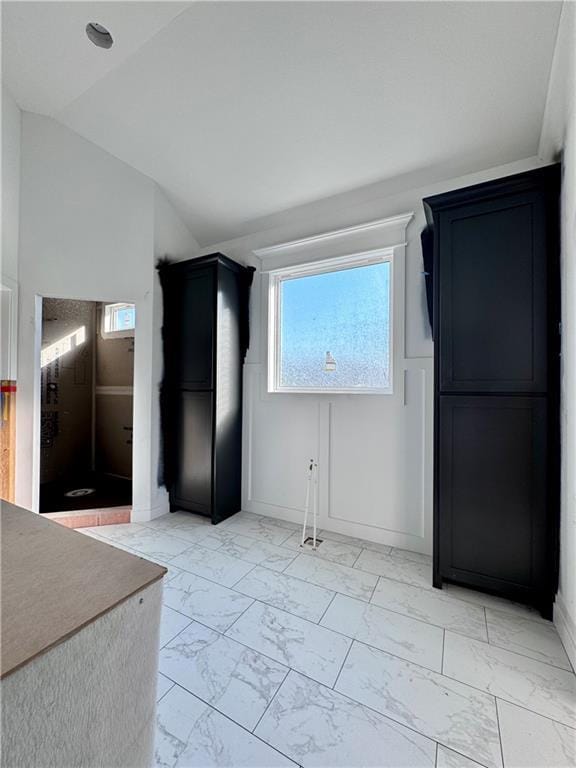 10332 N Potter Ave, Kansas City, MO 64157 - unfurnished dining area featuring light marble finish floors and lofted ceiling