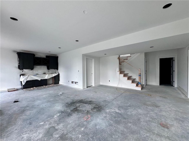10332 N Potter Ave, Kansas City, MO 64157 - unfurnished living room featuring unfinished concrete floors, stairs, and baseboards