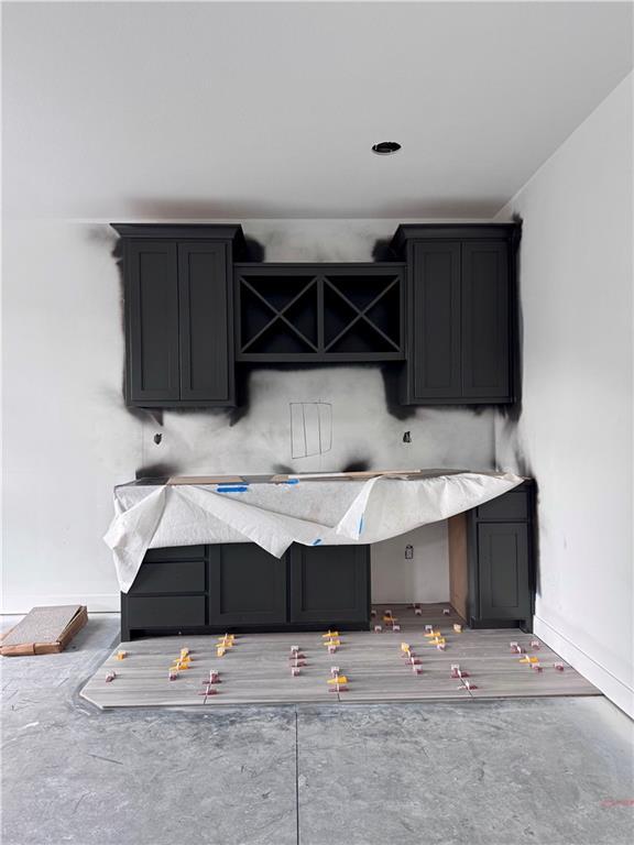 10332 N Potter Ave, Kansas City, MO 64157 - kitchen with concrete flooring, baseboards, and light stone counters