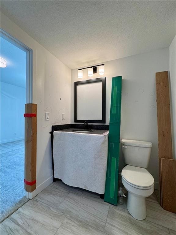 10332 N Potter Ave, Kansas City, MO 64157 - bathroom with vanity, toilet, a textured ceiling, and baseboards