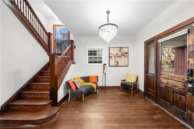 living area with a notable chandelier, dark hardwood / wood-style flooring, and a wealth of natural light