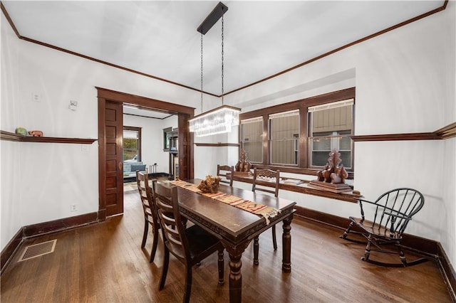 dining space featuring ornamental molding and dark wood-type flooring