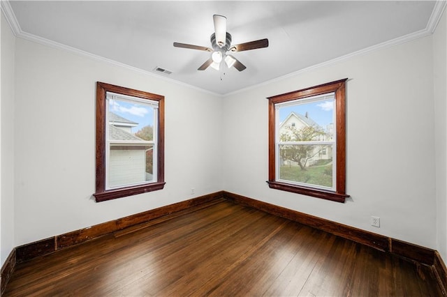 spare room with ornamental molding, a healthy amount of sunlight, and hardwood / wood-style floors