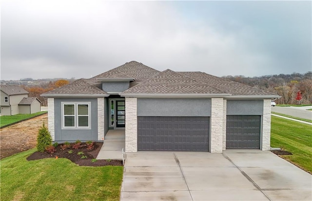 prairie-style house with a garage and a front lawn