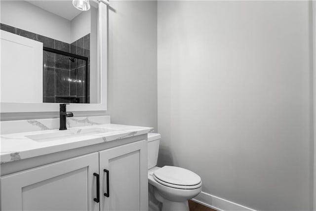 bathroom with vanity, toilet, and a shower with shower door