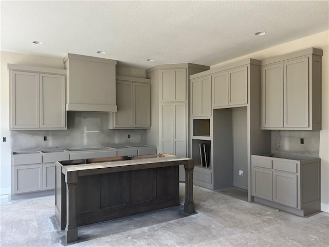 17154 S Heatherwood St, Olathe, KS 66062 - kitchen with gray cabinets, a textured ceiling, a center island, recessed lighting, and premium range hood