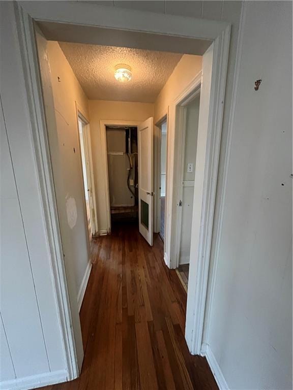 hall featuring dark hardwood / wood-style flooring and a textured ceiling