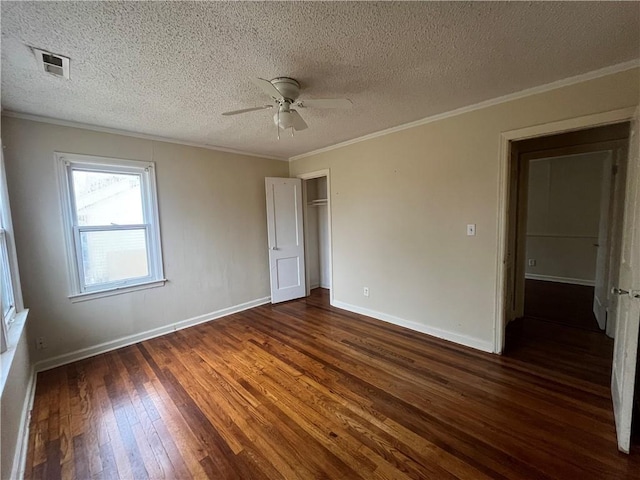 unfurnished bedroom with dark wood-type flooring, crown molding, a textured ceiling, a closet, and ceiling fan