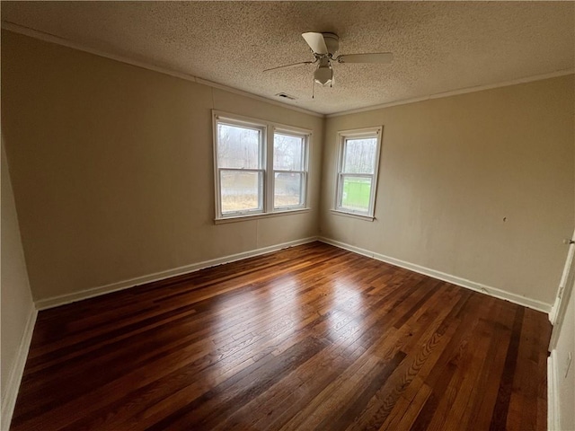 spare room with ceiling fan, dark wood-type flooring, ornamental molding, and a textured ceiling