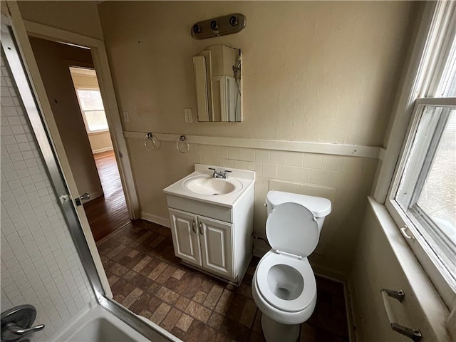 bathroom with tile walls, vanity, and toilet