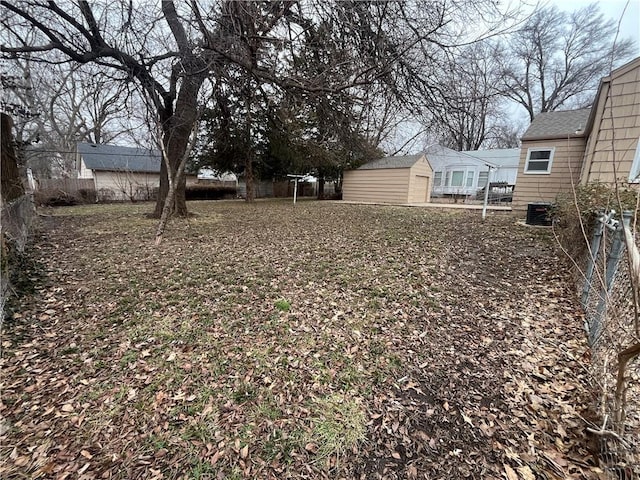 view of yard with central AC and a storage unit