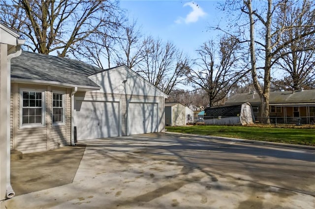 view of side of property with a storage unit, a lawn, and a garage