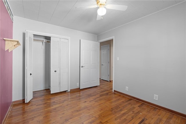 unfurnished bedroom with crown molding, ceiling fan, dark hardwood / wood-style floors, and a closet