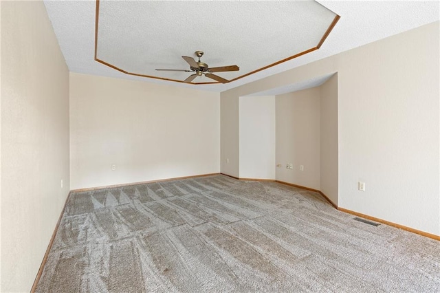 carpeted empty room featuring ceiling fan and a textured ceiling