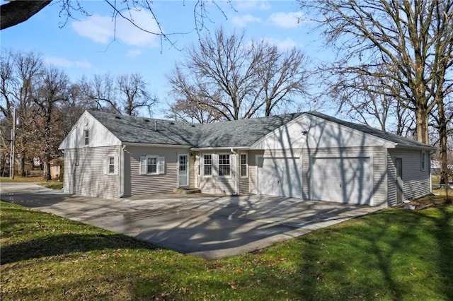 back of house with a garage and a yard