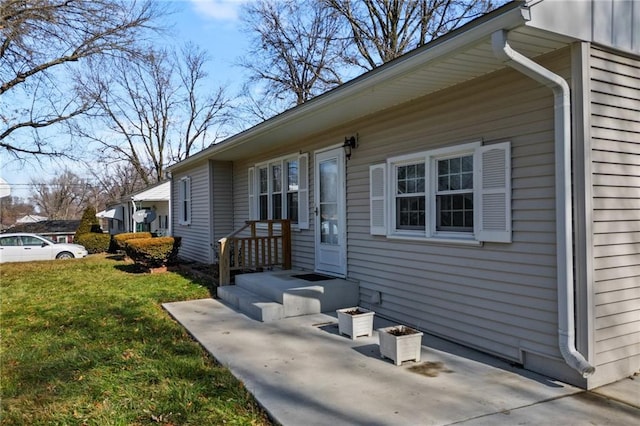 entrance to property featuring a lawn