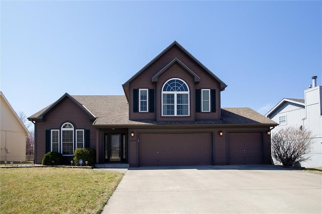 traditional home featuring a garage, driveway, a shingled roof, and a front yard