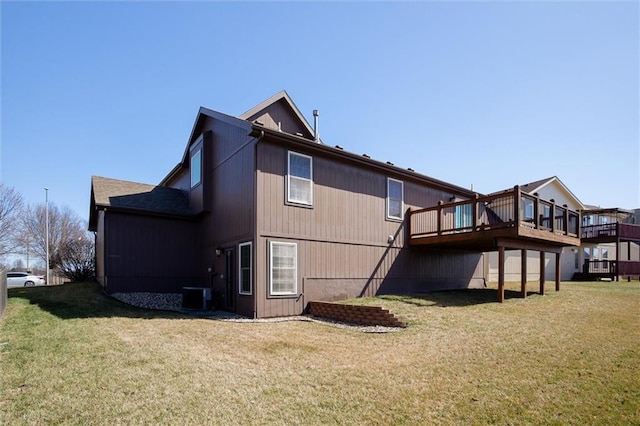 rear view of house with a lawn, central AC, and a wooden deck