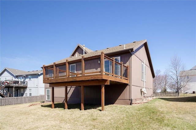 back of house with a deck, a yard, and fence