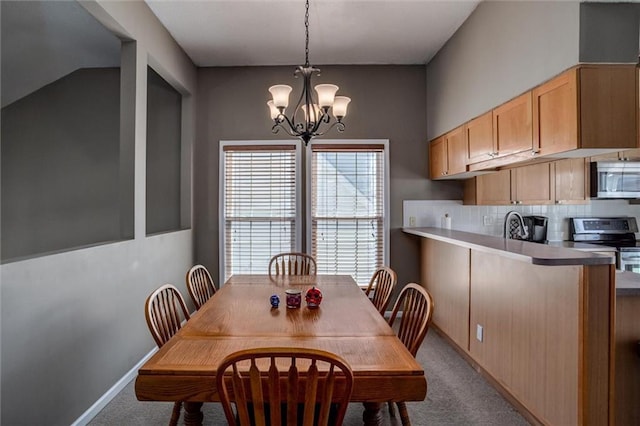 dining area with a notable chandelier, baseboards, and carpet floors