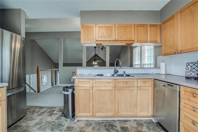 kitchen featuring light brown cabinets, a sink, stone finish flooring, appliances with stainless steel finishes, and light countertops