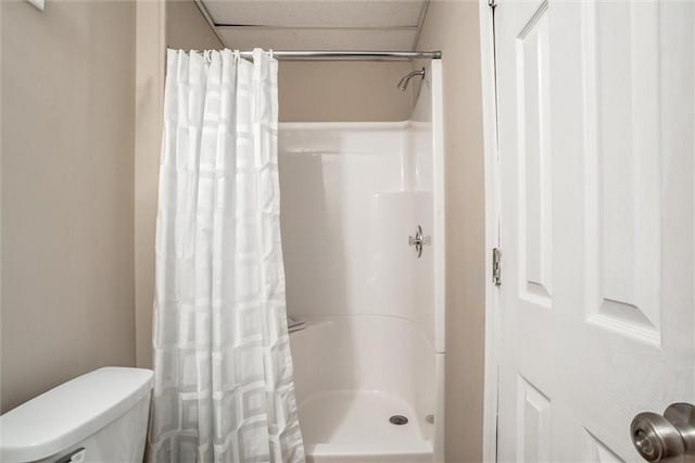 bathroom featuring curtained shower and toilet