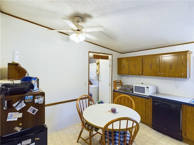 kitchen with stacked washer and dryer, lofted ceiling, dishwasher, and a textured ceiling