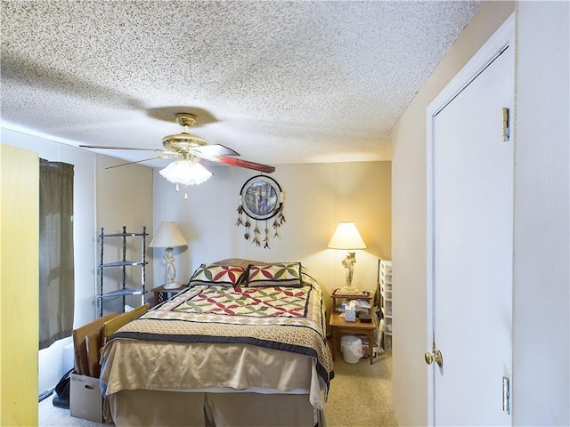 carpeted bedroom featuring ceiling fan and a textured ceiling