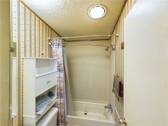 bathroom featuring shower / bathtub combination with curtain and a textured ceiling