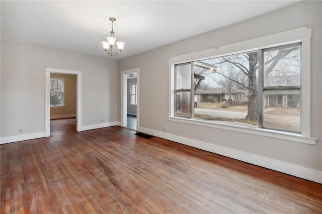 unfurnished dining area with hardwood / wood-style flooring, a chandelier, and a wealth of natural light