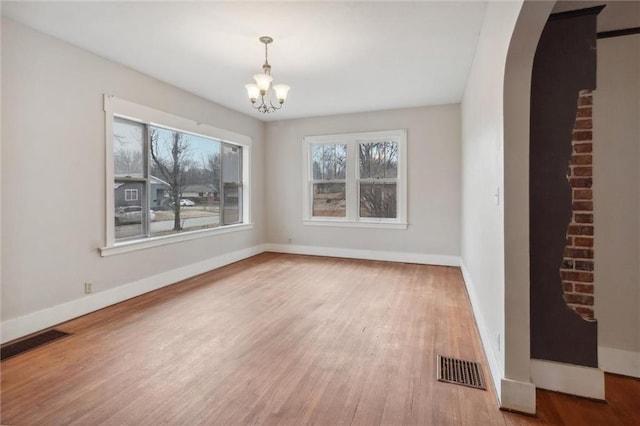 unfurnished dining area featuring wood-type flooring and a notable chandelier