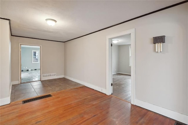 empty room with crown molding and hardwood / wood-style flooring