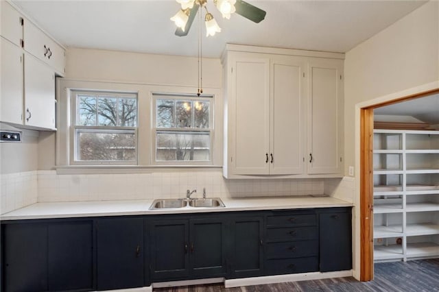 kitchen featuring decorative light fixtures, sink, white cabinets, decorative backsplash, and dark wood-type flooring