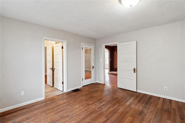 unfurnished bedroom with hardwood / wood-style floors and ensuite bath